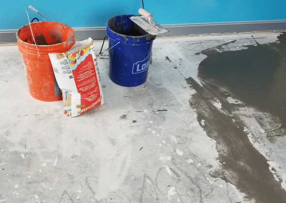A picture of a concrete level with flooring cement and tools used in concrete leveling.