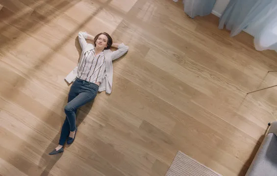 Carefree woman lying on clean hardwood floor