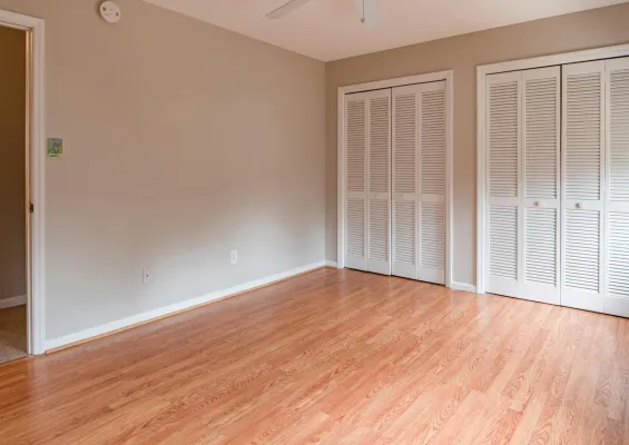 a picture of renovated bedroom rooms, with grey painted walls and with two white walk-in closet doors.